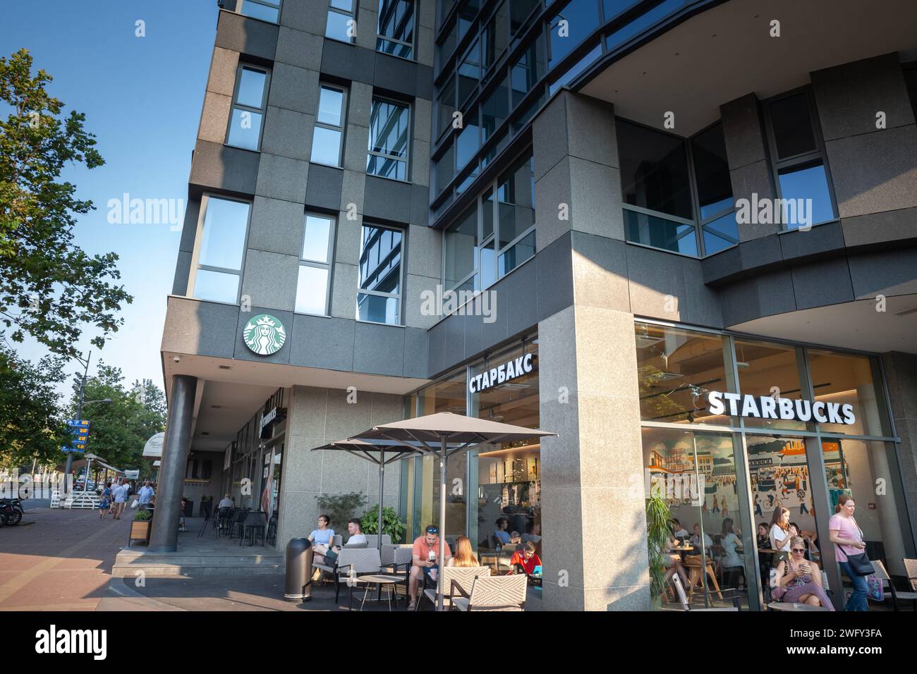 Immagine di un cartello con il logo di Starbucks in cirillico e inglese davanti al loro negozio locale a belgrado, serbia. Starbucks Corporation è una AM Foto Stock