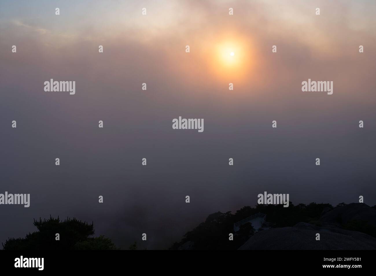 Un sole dorato tramonta nella White Cloud Scenic area vista dal Turtle Peak nelle Huangshan Yellow Mountains. Foto Stock