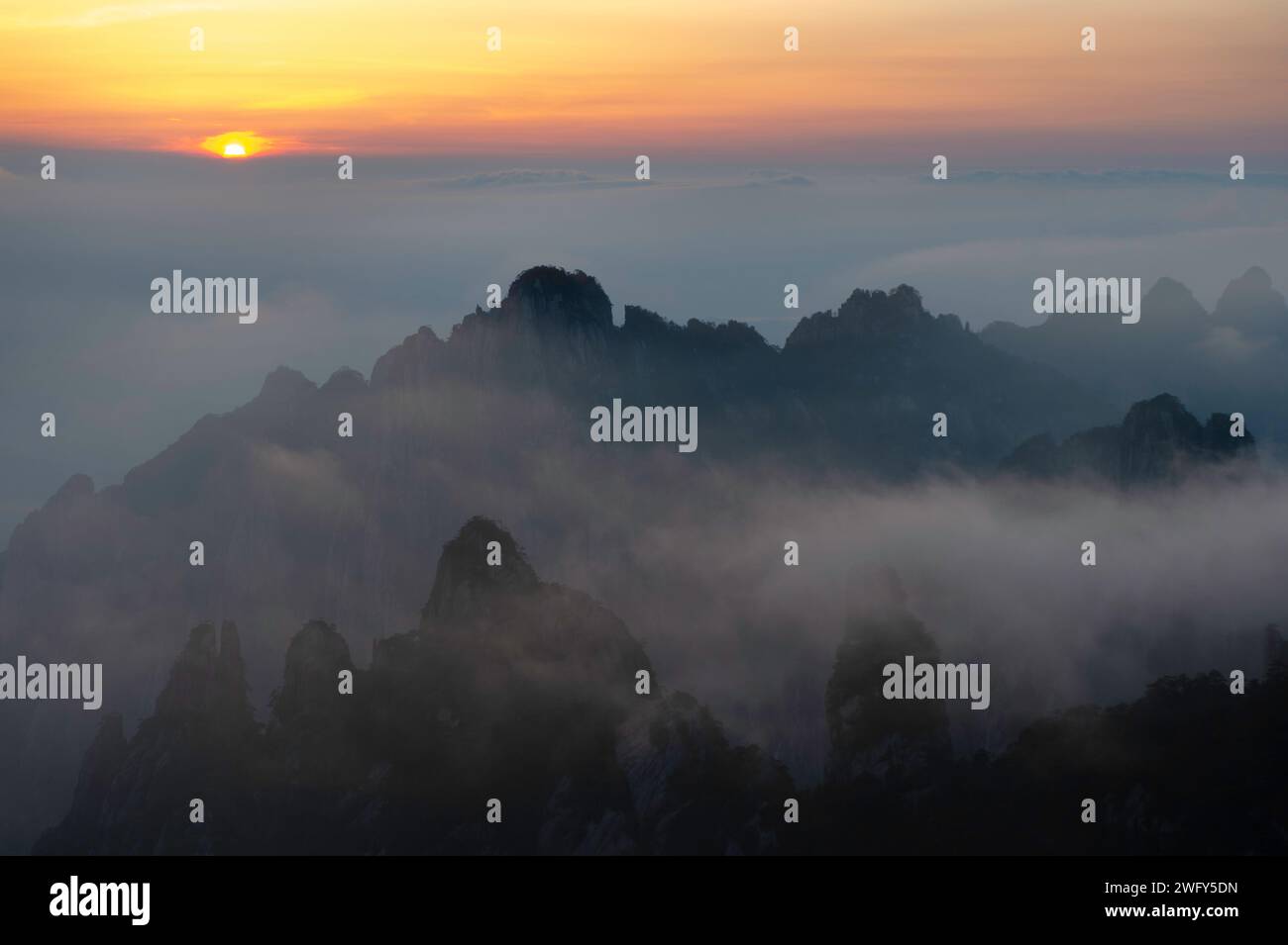 Un sole dorato tramonta sopra il Mare delle nuvole visto dal Turtle Peak nelle montagne gialle di Huangshan. Foto Stock