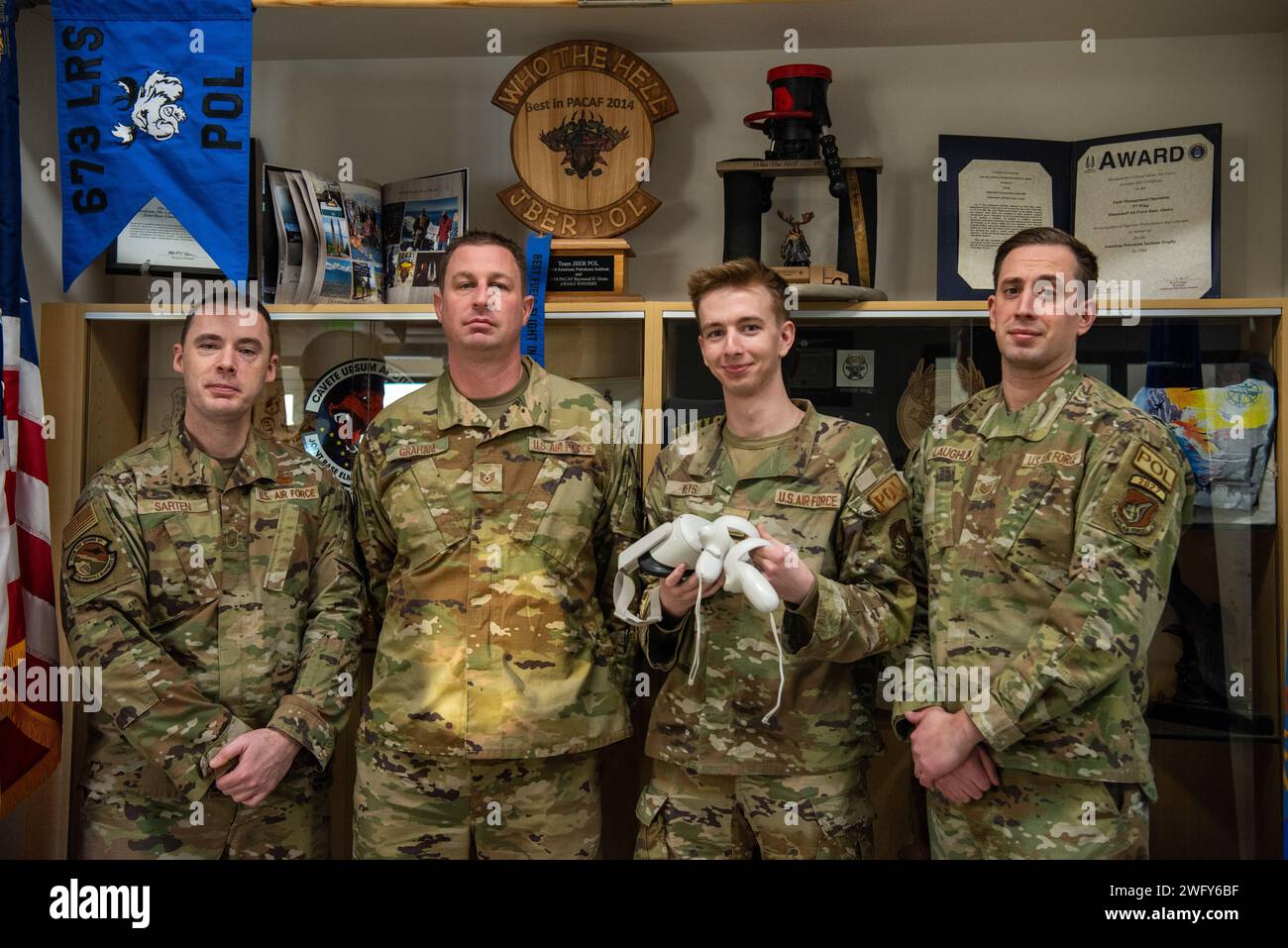 Da sinistra: U.S. Air Force Senior Master Sgt. Fredrick Sarten, Tech. Sgt. Curtis Graham, Senior Airman Aaron Keys e Tech. Il Sgt. Jordan Laughlin, tutti assegnati al 673d Logistics Readiness Squadron, posa con il Joint base Elmendorf-Richardson Fuels Trainer su JBER, Alaska, 17 gennaio 2024. Il JBER Fuels Trainer è un programma di realtà virtuale sviluppato da Res3D, una società locale di media digitali, che mira a colmare un divario formativo per la comunità dei combustibili. L'obiettivo del programma è quello di digitalizzare l'intero campo della carriera in un singolare ambiente di formazione digitale che consenta ai combattenti di guerra di addestrarsi in un rischio Foto Stock