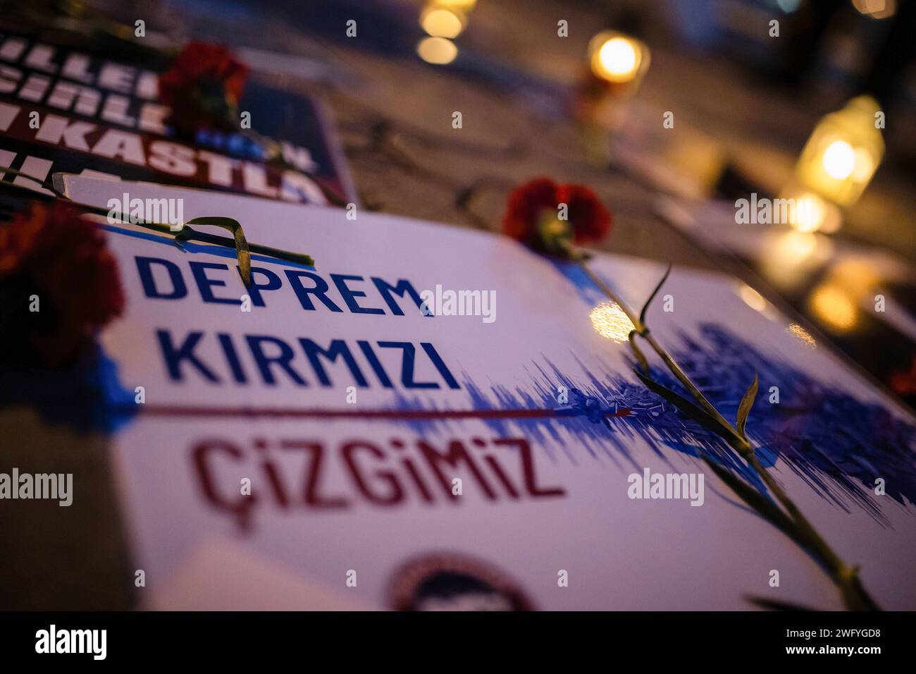 Istanbul, Turchia. 1 febbraio 2024. Un garofano visto con uno striscione che dice "terremoto è la nostra linea rossa” scritto in turco. Il 06.02.2023, alle 04:17 e alle 13:24 ora turca, si verificarono due terremoti di magnitudo 7,7 e 7,6, con epicentri a Pazarc?k (Kahramanmaras) ed Elbistan (Kahramanmaras). I parenti di coloro che hanno perso la vita nel terremoto si sono riuniti al molo di Kadikoy e hanno gettato garofani in mare dopo la dichiarazione della stampa. Credito: SOPA Images Limited/Alamy Live News Foto Stock