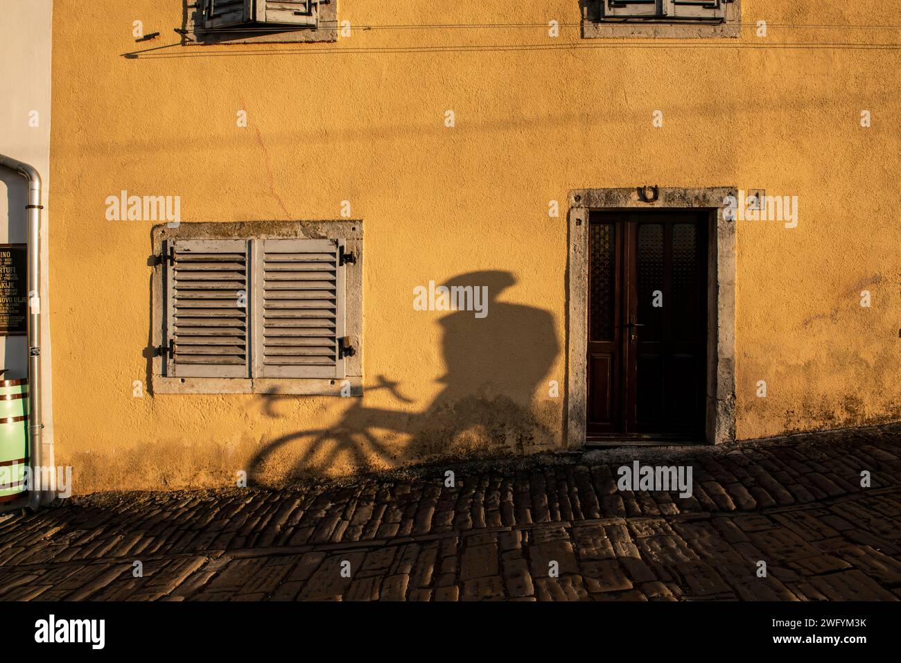 Ombra di ciclista sulla facciata, a Motovun, Istria, Croazia Foto Stock