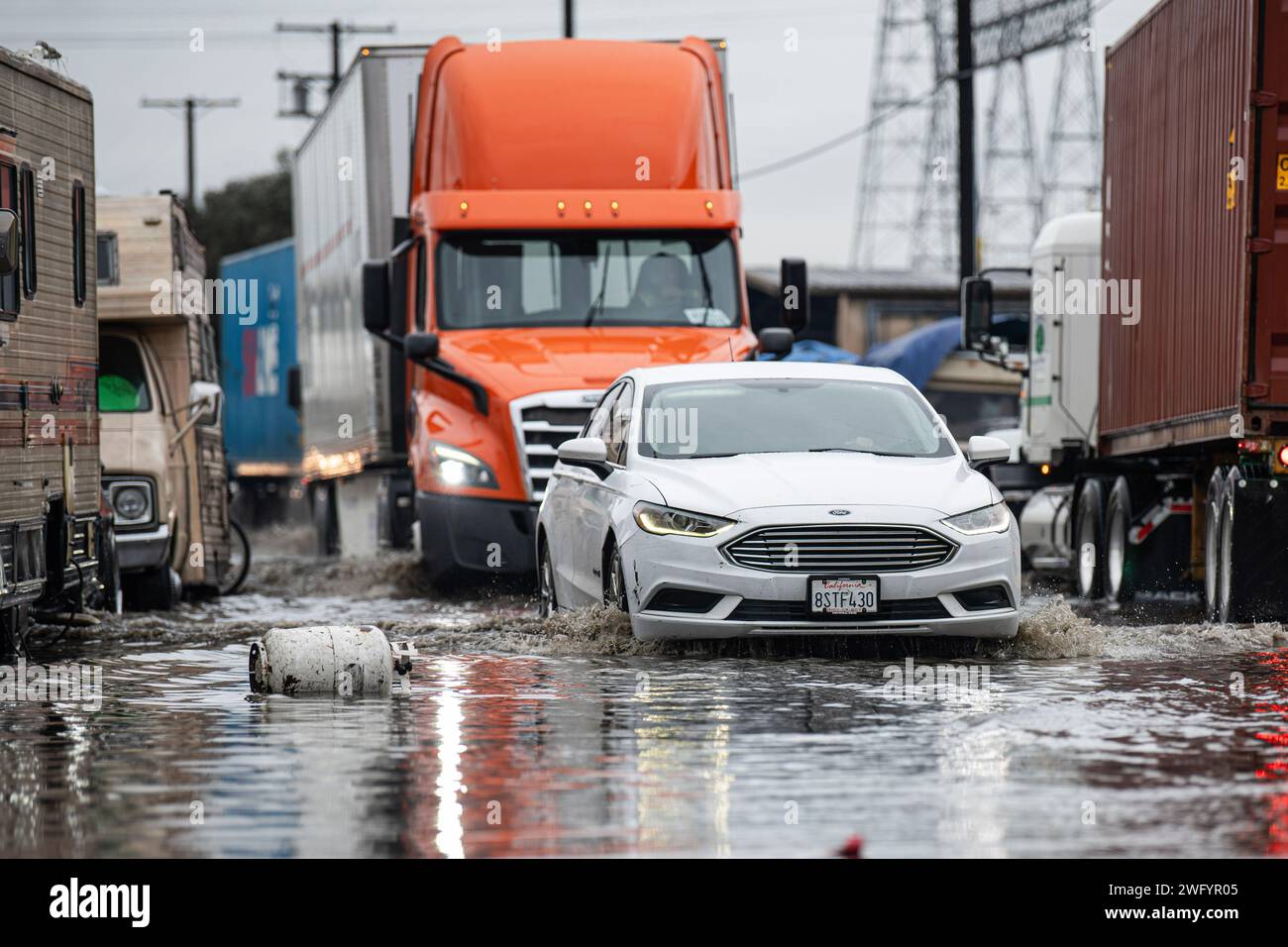 Long Beach, Stati Uniti. 1 febbraio 2024. I veicoli viaggiano attraverso le acque alluvionali in aumento mentre un serbatoio di propano galleggia nelle vicinanze. 4 veicoli sono rimasti intrappolati nelle acque alluvionali che si sono verificate al largo di Willow St. A Long Beach. (Foto di Jon Putman/SOPA Images/Sipa USA) credito: SIPA USA/Alamy Live News Foto Stock