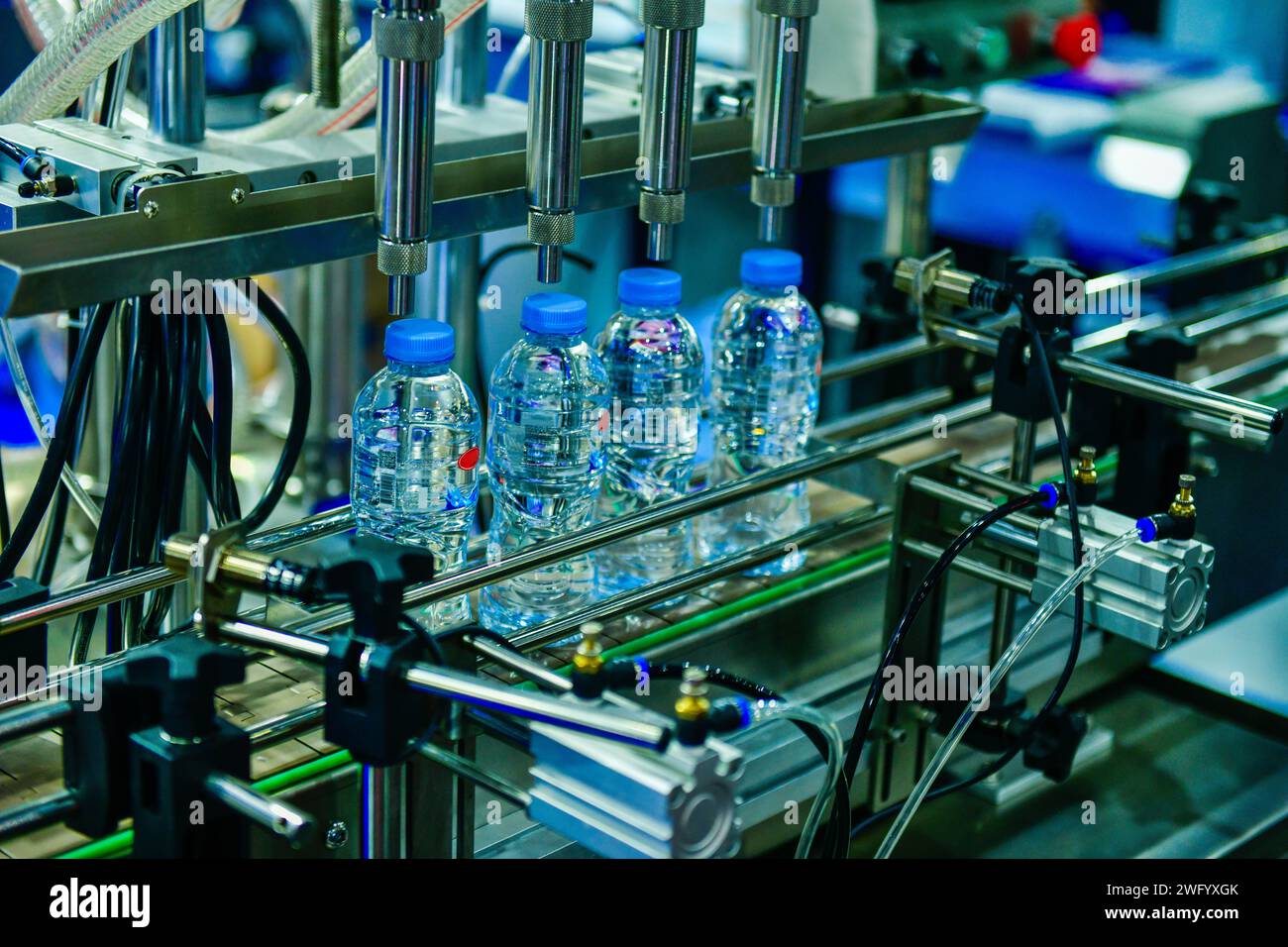 Cancellare le bottiglie di plastica trasferire sul trasportatore automatizzato di sistemi di automazione industriale per il pacchetto Foto Stock