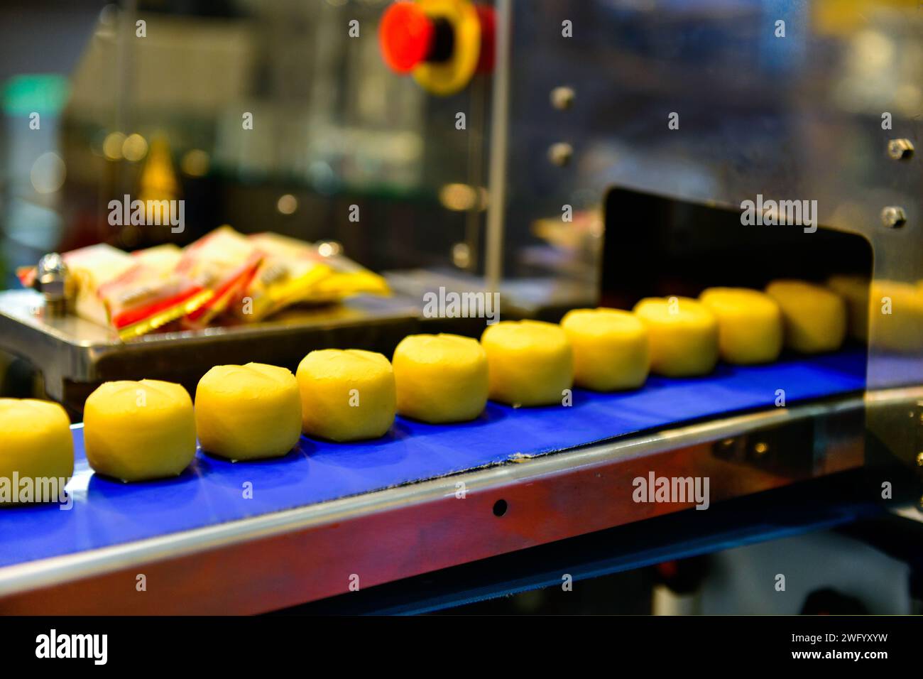 Linea di produzione automatica di snacks dorati su macchine per nastri trasportatori in fabbrica, produzione alimentare industriale. Foto Stock
