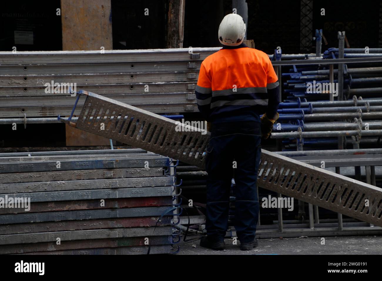 Un operaio edile che tiene un tubo metallico Foto Stock