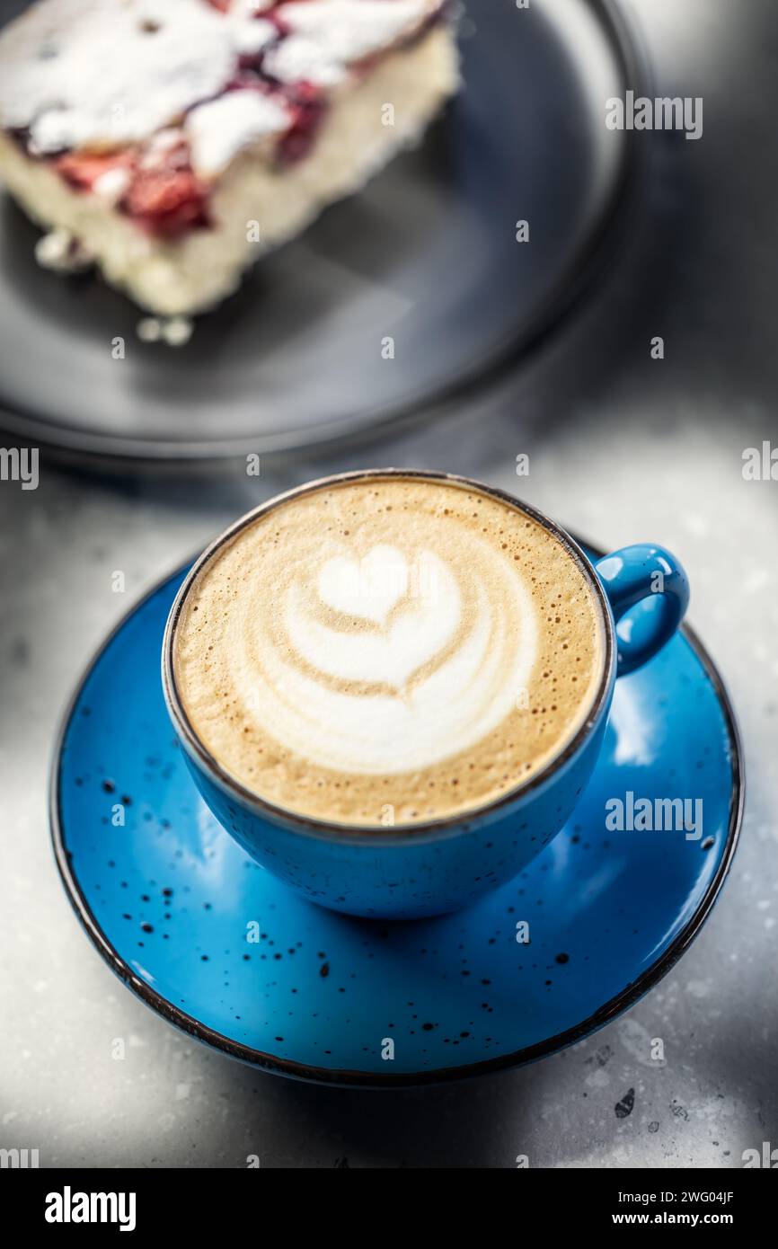 Caffè cappuccino tradizionale con torta sul tavolo del caffè. Foto Stock