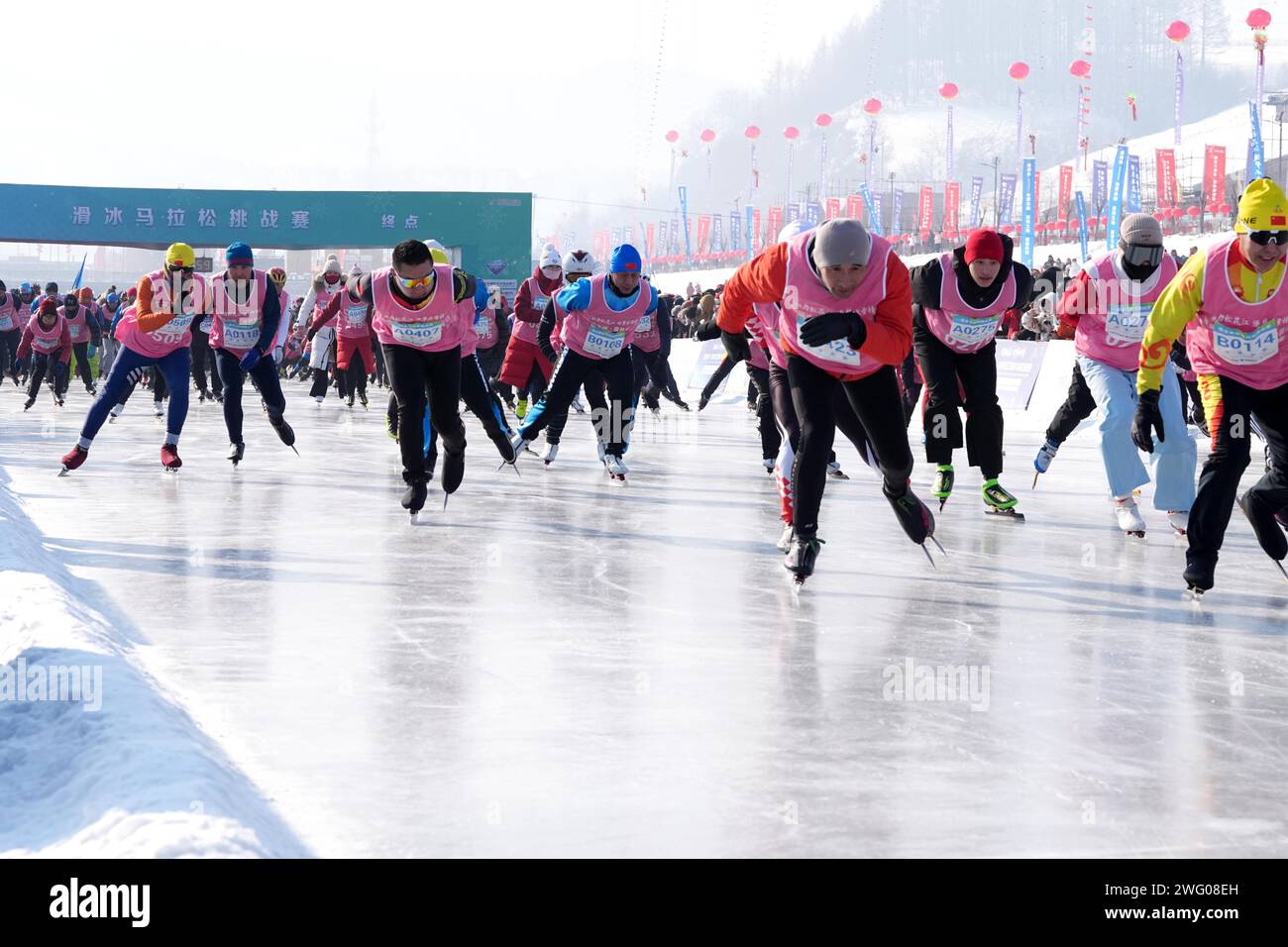 I piloti competono nella gara di pattinaggio durante la prima China Jilin Songhua River Ice Skating Marathon nella contea di Jingyu, Baishan City, nord-est del CH Foto Stock