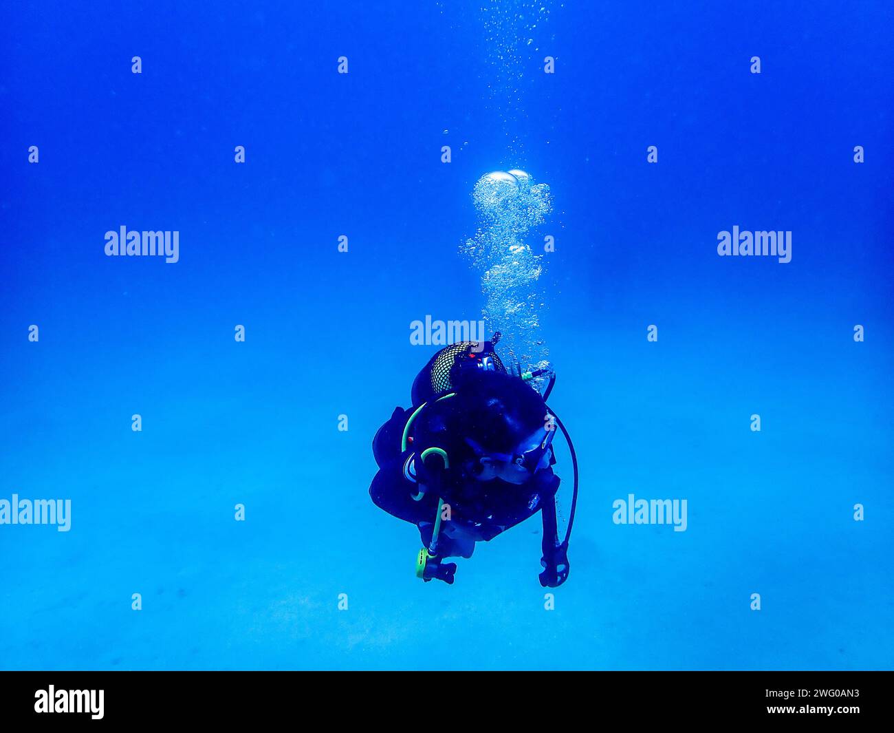 Affascinanti profondità blu: Un subacqueo, bolle che salgono, in un sereno abbraccio alle meraviglie sottomarine di Lanzarote Foto Stock