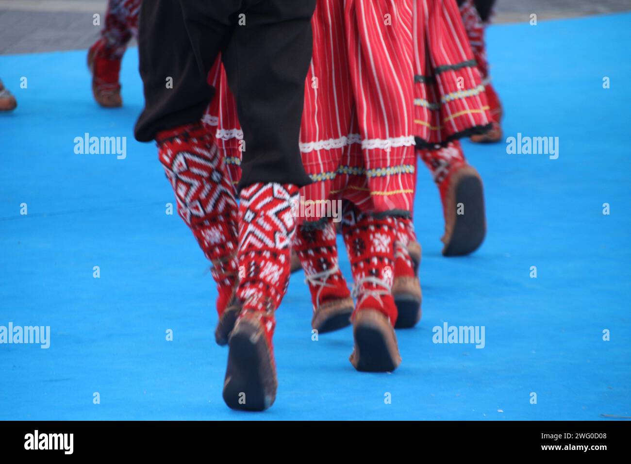 Gruppo di individui in elegante abbigliamento che si scambiano sguardi in un raduno sociale: Ballerini serbi in un festival Foto Stock