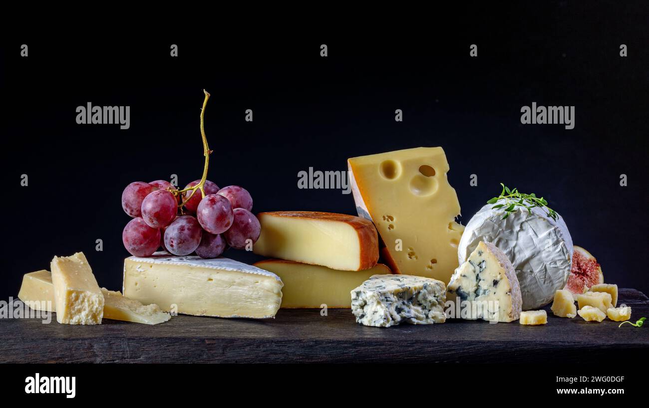 natura morta con vari formaggi su sfondo nero Foto Stock