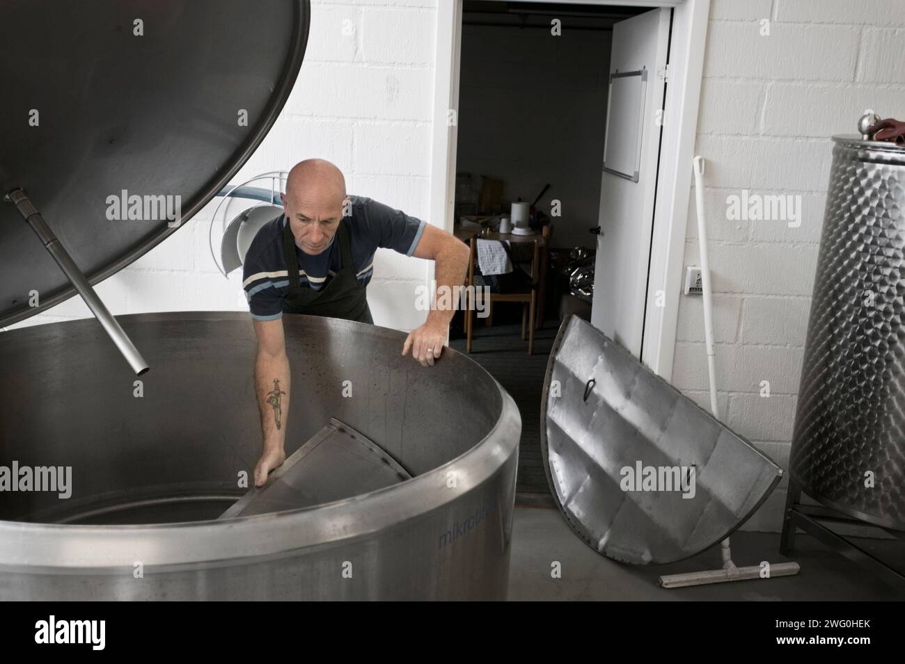 Il birraio prepara i serbatoi per il processo di filtraggio presso il piccolo birrificio di Raervig, Danimarca. Foto Stock