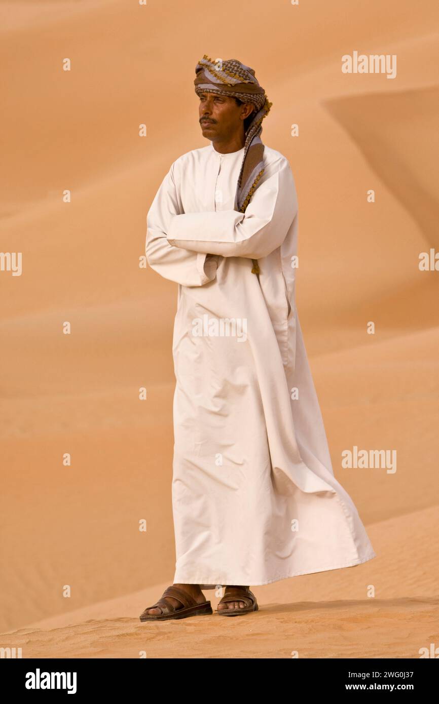 Ritratto di un uomo dell'Oman sulle dune di sabbia del quartiere vuoto, AR Rub al Khali, Oman. Foto Stock