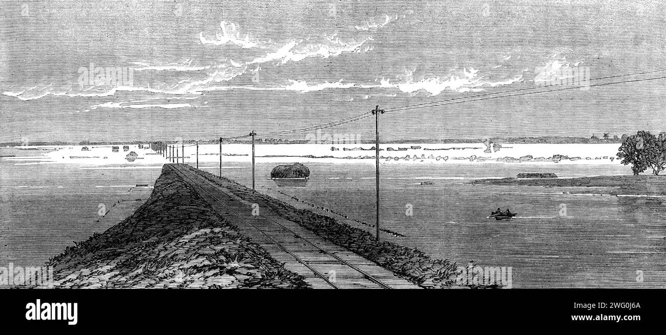 The Flood in the Fens: La ferrovia sommersa tra Lynn e Wisbeach, 1862. "Dal vertice del ponte ferroviario di livello medio è stata presentata quasi tutta la portata del paese allagato. Per quanto l'occhio potesse raggiungere su ogni lato, di circa sette o otto miglia di lunghezza, le acque terribili si sono sparse sopra lo specchio... subito prima di noi la ferrovia, per una distanza di due miglia e mezzo, è stata sommersa. L'acqua era salita a circa la metà dell'altezza dei segnali e dei telegrafi...qui e lì si vedevano le finestre superiori di qualche casale, o il tetto di paglia di un pollice Foto Stock