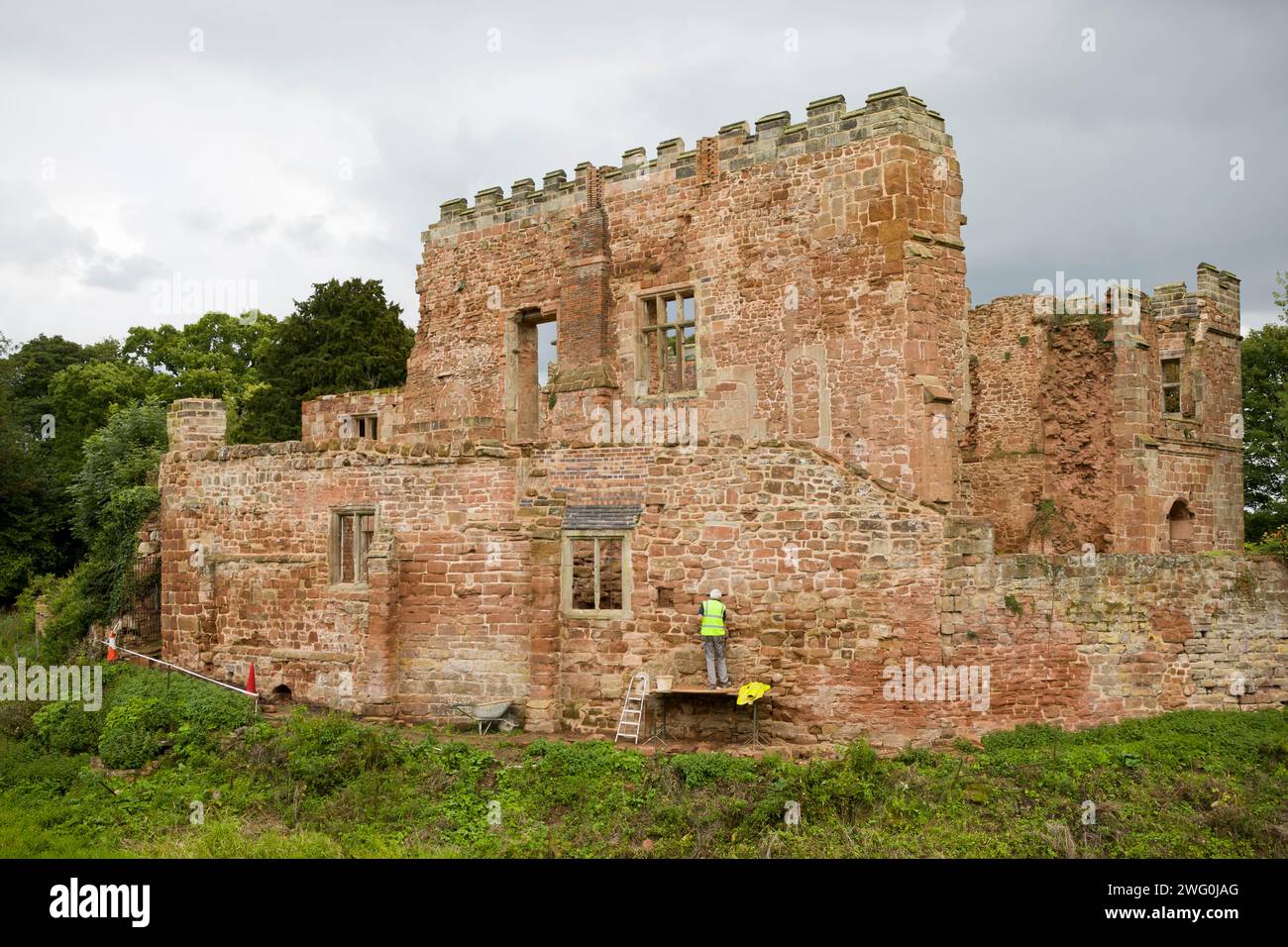 Un uomo lavora per restaurare il castello di Astley per il Landmark Trust nel Warwickshire, nel Regno Unito. Foto Stock