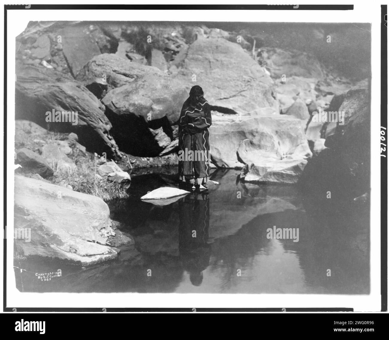 Nature's mirror-Navaho, 1904, c1904. Donna in piedi sulla roccia in una pozza d'acqua riflettente. Foto Stock