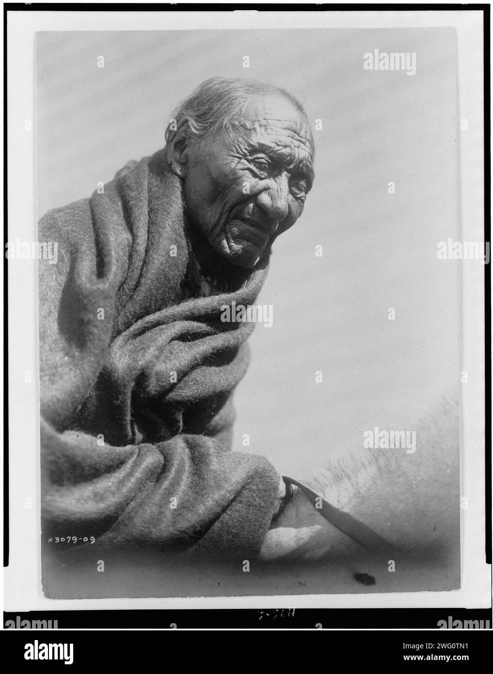 Buongiorno Eagle, c1910. Anziano Piegan, ritratto a mezza lunghezza, avvolto in coperta, seduto a cavallo, rivolto verso la parte anteriore. Foto Stock