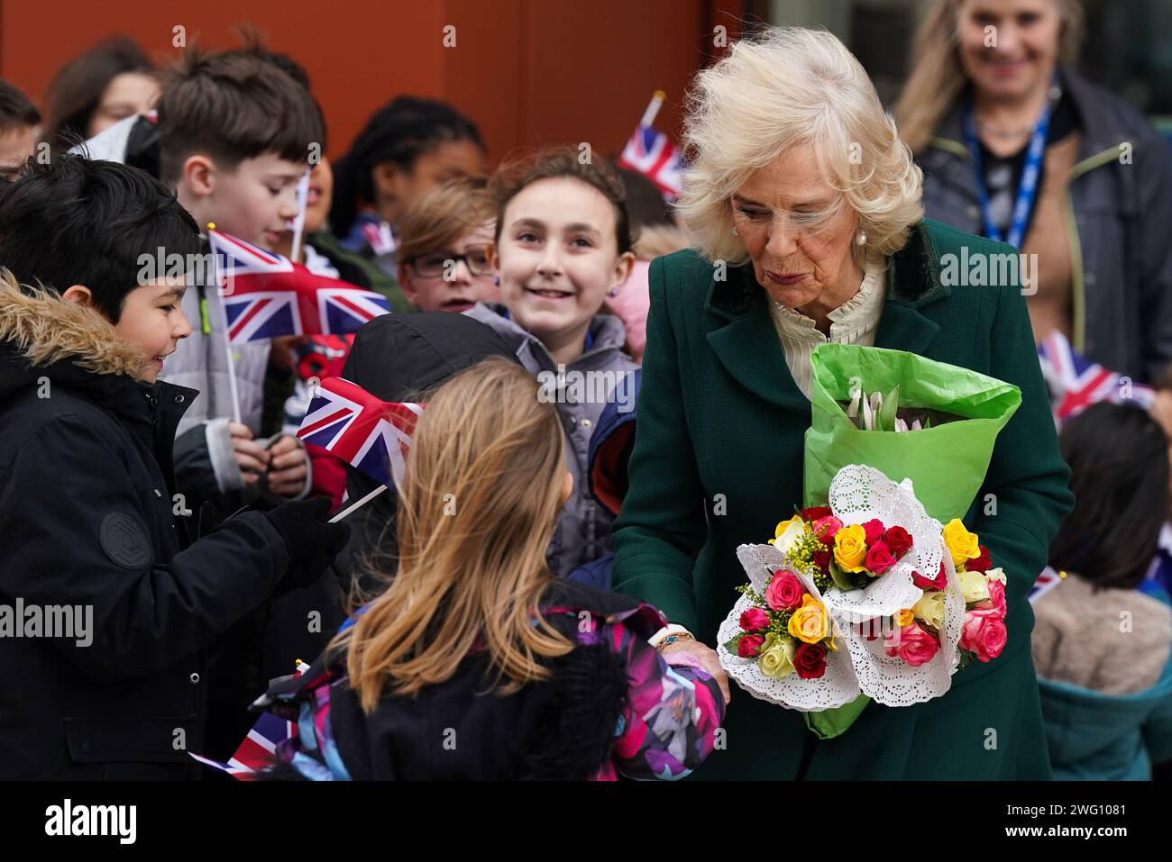 La regina Camilla, nel suo ruolo di presidente del Royal Voluntary Service, stringe la mano a un bambino mentre lascia una visita al Meadows Community Centre di Cambridge. Data immagine: Venerdì 2 febbraio 2024. Foto Stock