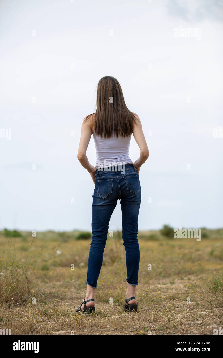 Donna con vista posteriore in piedi nel campo Foto Stock
