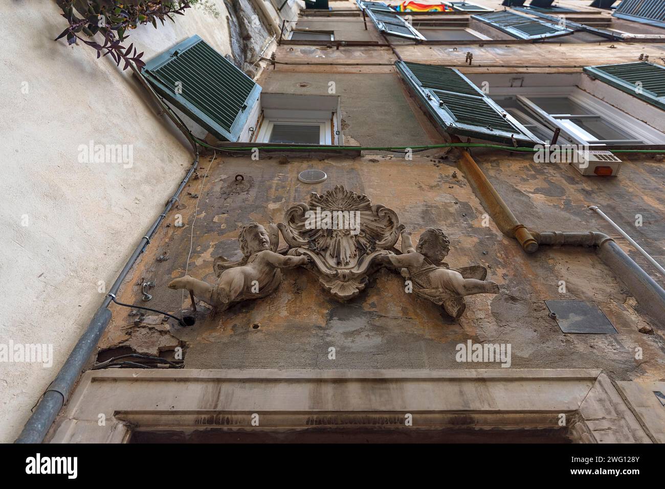 L'Angelo si erge sopra un cancello d'ingresso nel centro storico della città, Genova, Italia Foto Stock