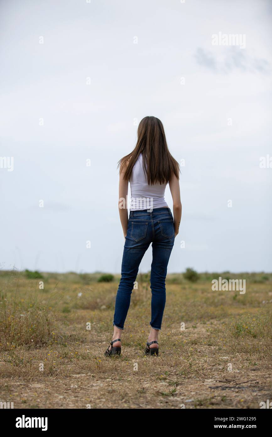 Donna con vista posteriore in piedi nel campo Foto Stock