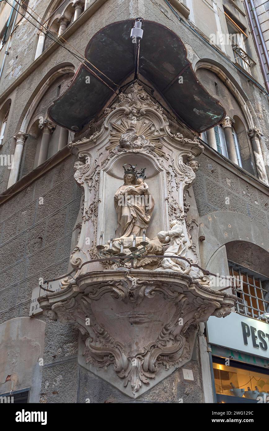 Figura della Madonna sotto un baldacchino in una casa d'angolo nel centro storico di Genova, Italia Foto Stock