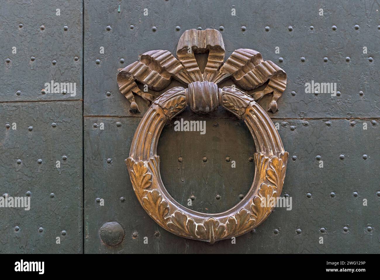 Una porta di ottone bussa su una porta d'ingresso nel centro storico di Genova, Italia Foto Stock