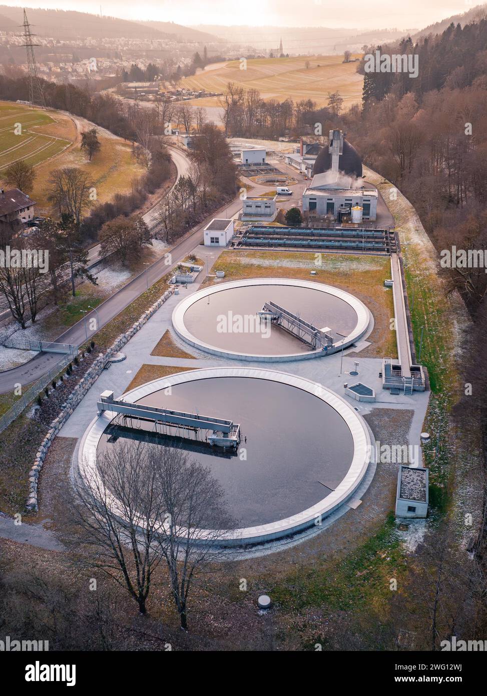 Vista aerea di un impianto di depurazione incentrato sui chiarificatori rotondi accanto a una foresta, Nagold, Foresta Nera, Germania Foto Stock