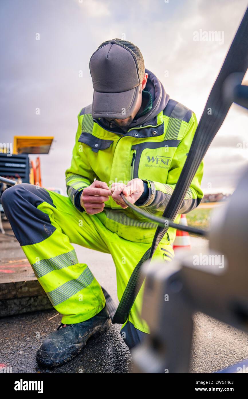 Lavoratore di indumenti di sicurezza che lavora manualmente su una macchina, costruzione in fibra di vetro, Nagold, Foresta Nera, Germania Foto Stock