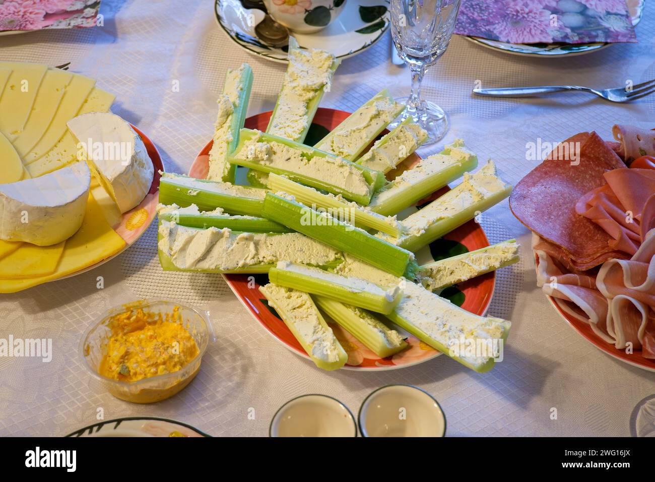 Tavolo da colazione con bastoncini di sedano ripieni e altri cibi. Foto Stock