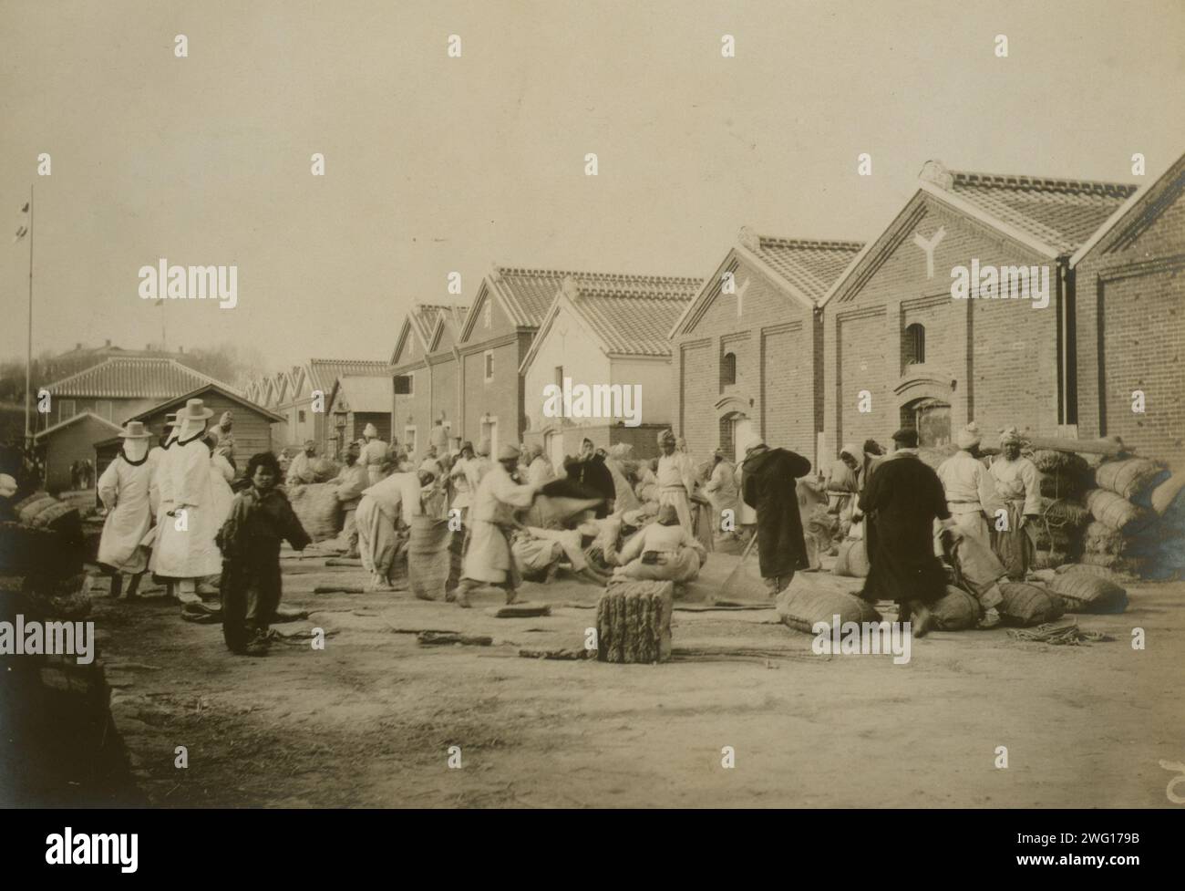 Magazzino di grano russo, Chemulpo, c1904. Coreani e lavoratori giapponesi riempiono sacchi di grano (?) in un magazzino. Foto Stock