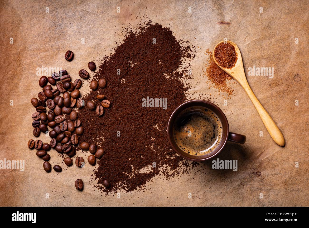 sullo sfondo rustico, con vista dall'alto, una tazza di caffè caldo e caffè macinato sparso e chicchi tostati sul fondo Foto Stock