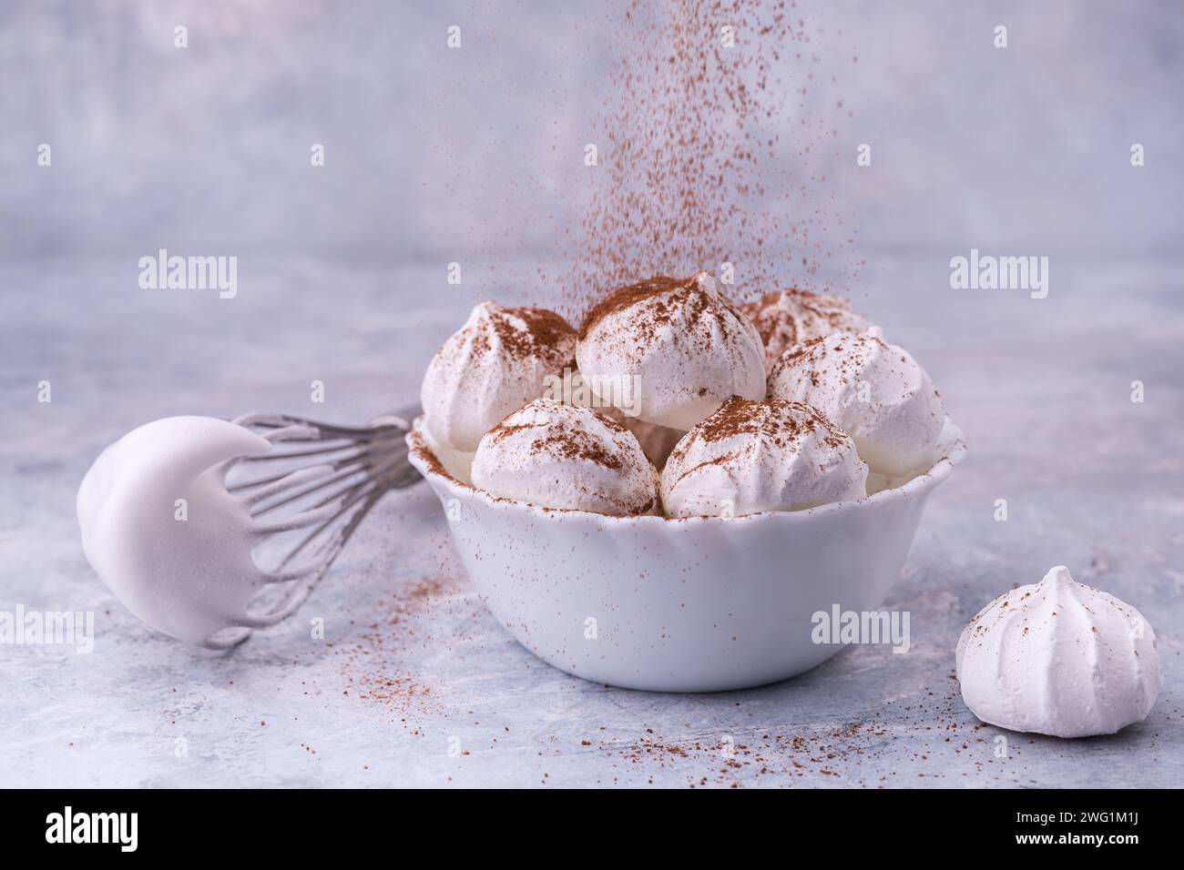 recipiente in ceramica bianca con meringhe decorato con spolveratura di cacao Foto Stock