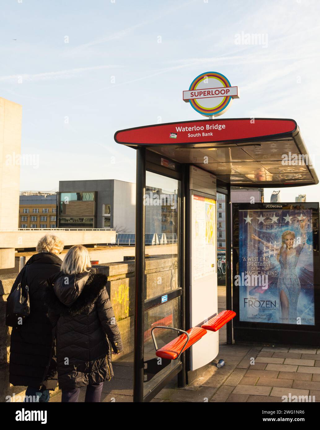 Due donne che camminano davanti a una colorata pista Superloop sul Waterloo Bridge, Londra, Inghilterra, Regno Unito Foto Stock