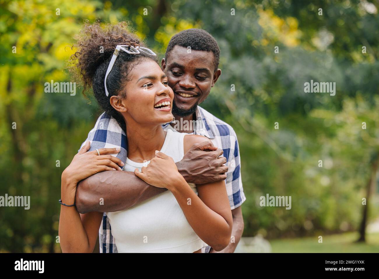 Appuntamento con due uomini e donne san valentino. Amante del nero africano al parco all'aperto, stagione estiva, tonalità di colore vintage Foto Stock