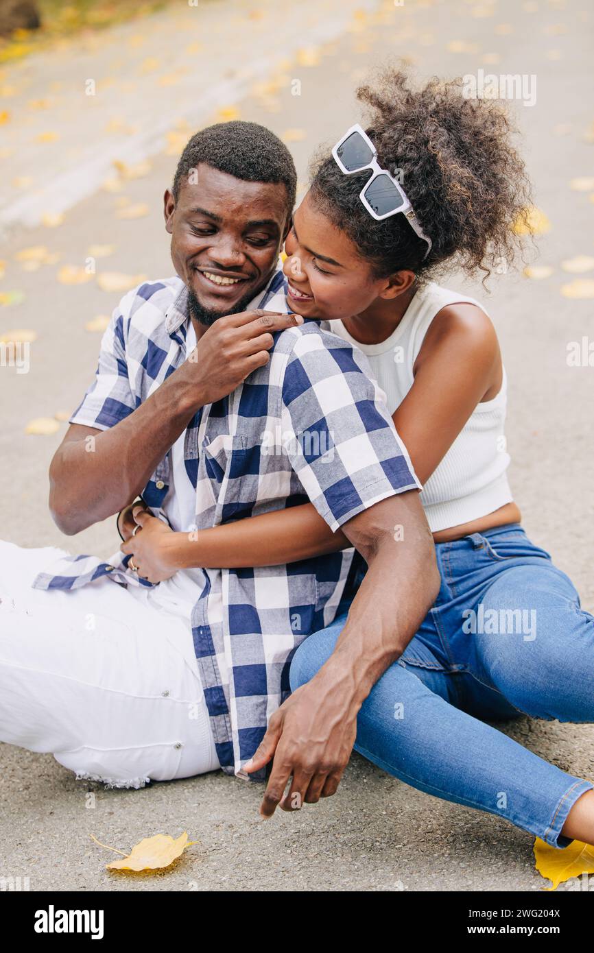 Appuntamento con due uomini e donne san valentino. Amante del nero africano al parco all'aperto, stagione estiva, tonalità di colore vintage Foto Stock