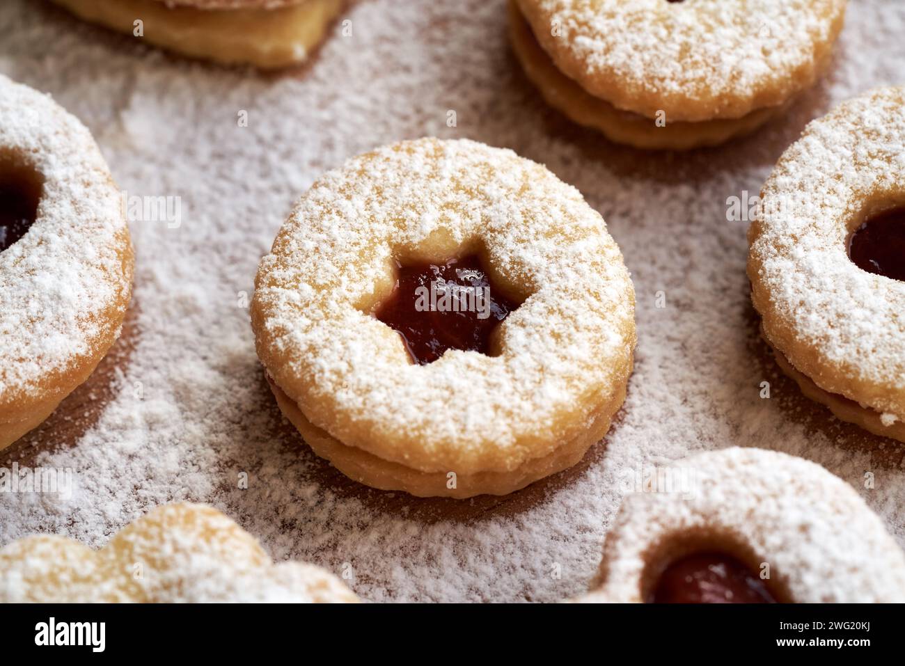 Biscotti di Natale Linzer ripieni di marmellata di fragole e spolverati di zucchero, primo piano Foto Stock