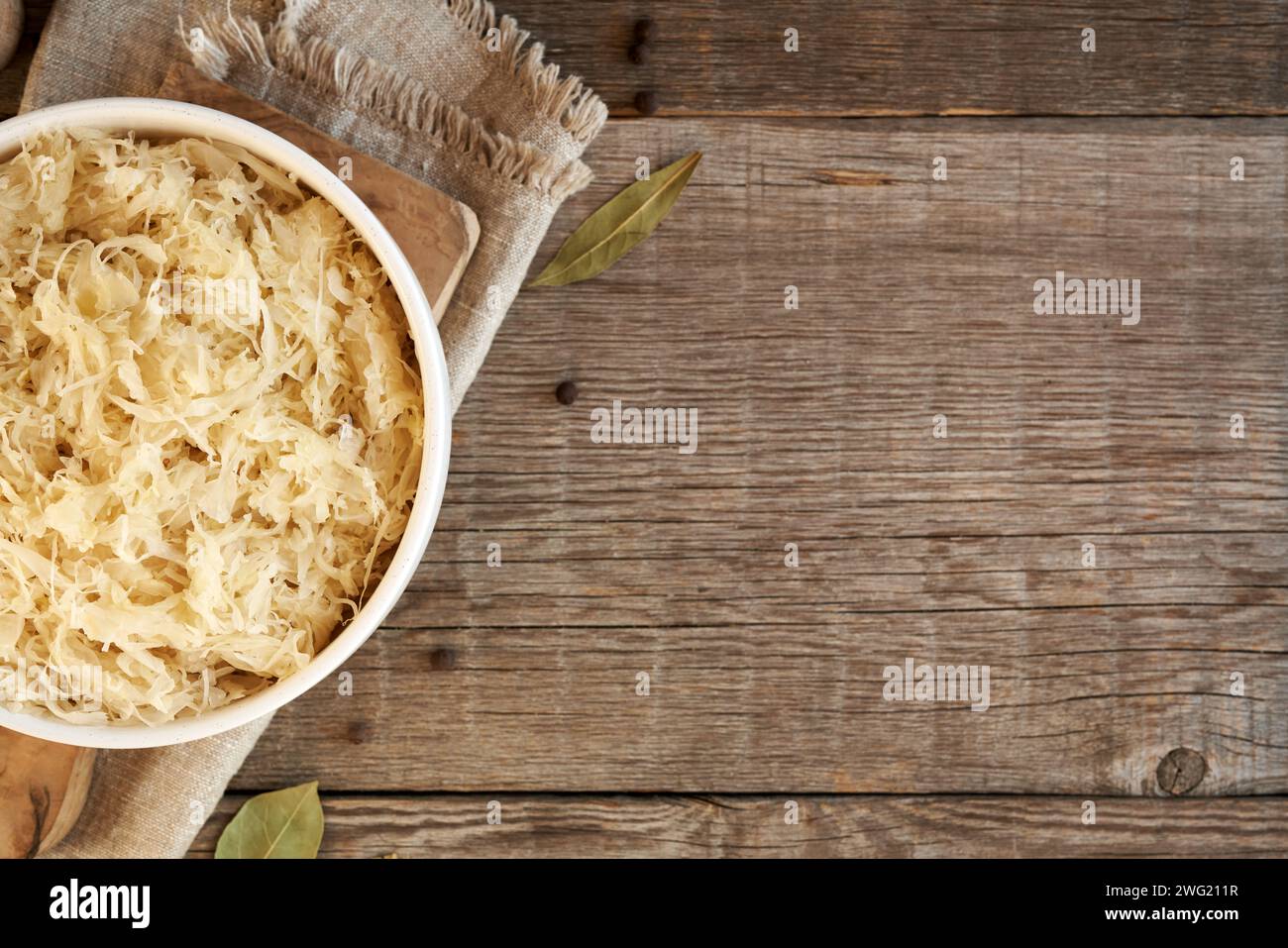 Cavolo fermentato o crauti fatti in casa in una ciotola su sfondo di legno con spazio per copiare, vista dall'alto Foto Stock