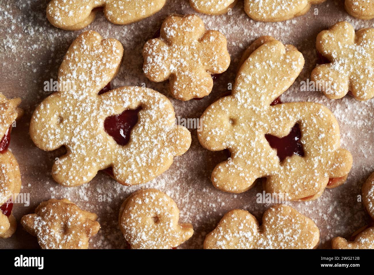 Biscotti al Linzer a forma di coniglietti pasquali ripieni di marmellata di fragole e spolverati di zucchero, vista dall'alto Foto Stock