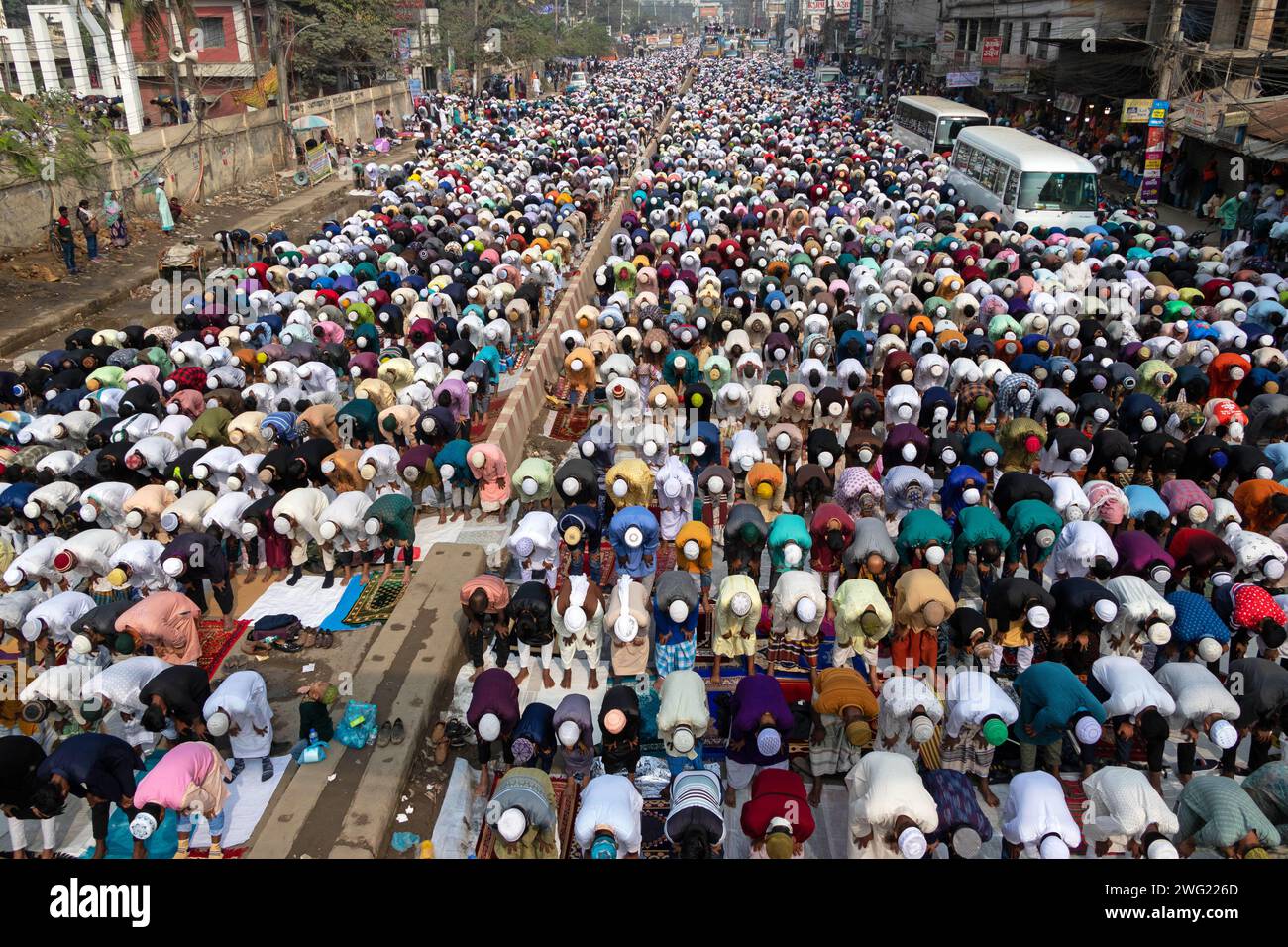 Tongi, Dacca, Bangladesh. 2 febbraio 2024. I devoti musulmani pregano nel mezzo di un trafficato incrocio stradale, causando l'arresto del traffico, a Tongi, Dacca, Bangladesh durante Bishwa Ijtema, uno dei principali raduni religiosi islamici osservati ogni anno. I campi di preghiera dedicati non sono sufficienti per gestire questo enorme numero di persone, quindi un gran numero di persone viene a Tongi, la strada principale di Dacca. Tutti i trasporti a terra e i passaggi pedonali sono sospesi durante questo periodo. La Bishwa Ijtema (Congregazione globale) è un raduno annuale di musulmani a Tongi, presso le rive del Riv Foto Stock