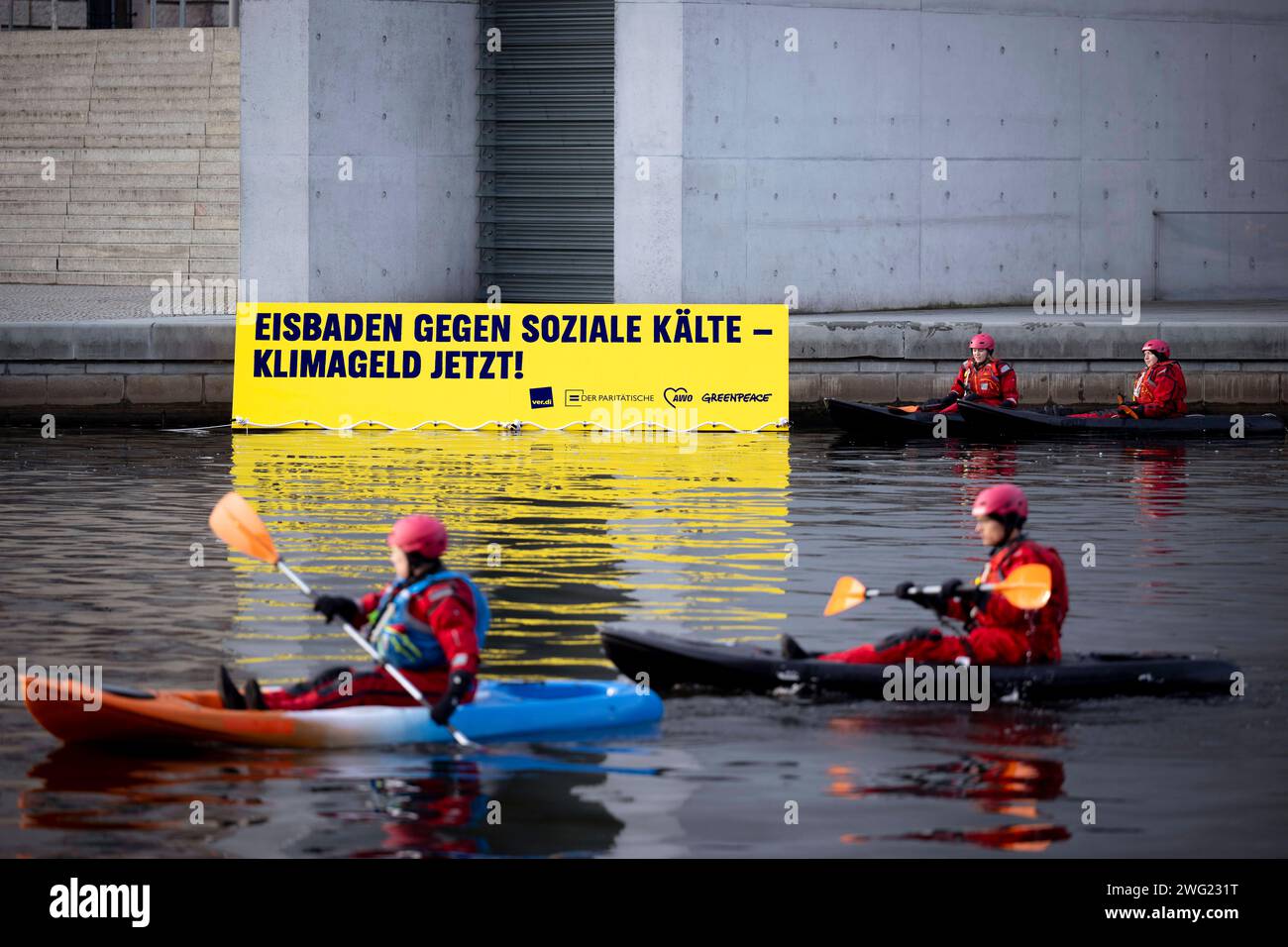 Protesta in Groenlandia - Klimageld DEU, Deutschland, Germania, Berlino, 30.01.2024 Demonstranten von Greenpeace AWO Verdi und Der Paritaetische Verband mit Transparent Eisbaden gegen soziale Kaelte Klimageld jetzt gegen Kuerzungen im sozialen Bereich und beim Klimaschutz bei den Beratungen zum Haushalt auf dem Fluss Spree vor dem Reichstag Sitz Deutscher Bundestag in Berlin Regiersviertel Berlin Der protest fordert mehr Geld fuer klimafreundliche Sozialinvestitionen im neuen Bundeshaushalt . Der Bundestag debattiert ab heute im Reichstag ueber den neuen Haushalt, der nach einem Urteil d Foto Stock