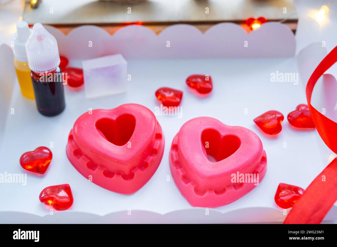 Sapone fatto a mano a forma di cuori per un regalo di San Valentino alla tua amata. Profumi e coloranti, base di sapone sul tavolo Foto Stock