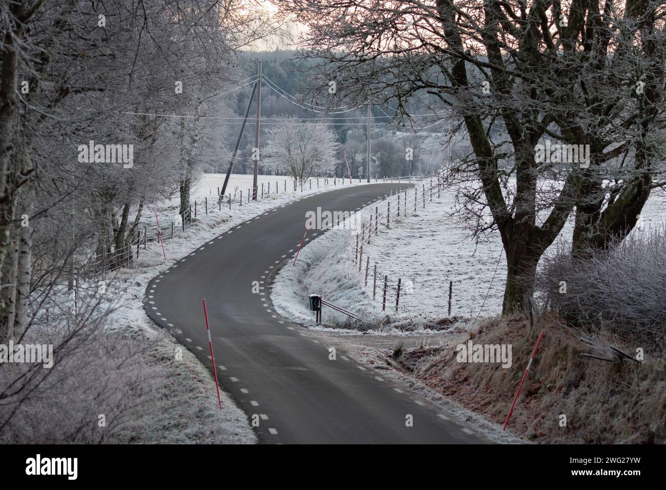 Strada di campagna in un paesaggio rurale ghiacciato in Svezia Foto Stock