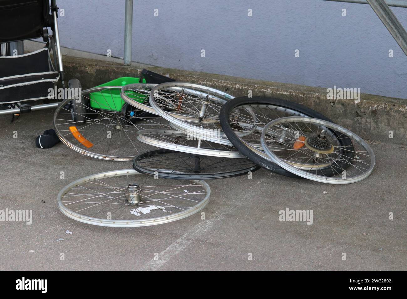 Ruote per biciclette gettate come rifiuti su un marciapiede Foto Stock