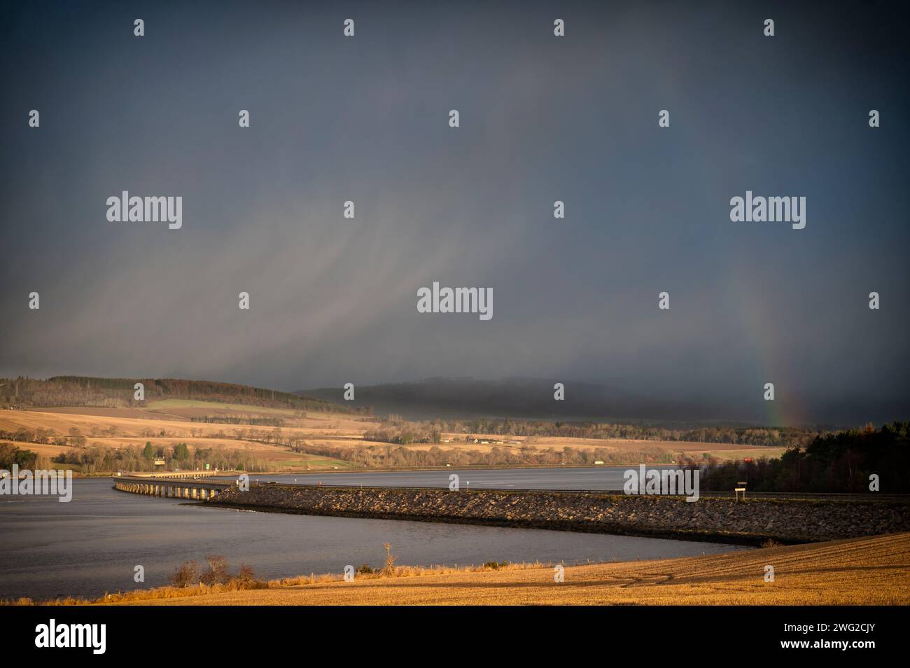 Uscendo in una fredda mattina d'inverno, il sole veniva spinto fuori dalla pioggia in arrivo sul Cromarty Firth, il ponte ancora cattura Foto Stock