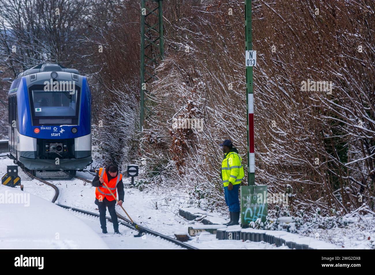 Francoforte sul meno: Il dipendente della DB Railway svolge il servizio invernale con scopa, posto di sicurezza, treno locale in piedi a Francoforte sul meno, Assia, He Foto Stock