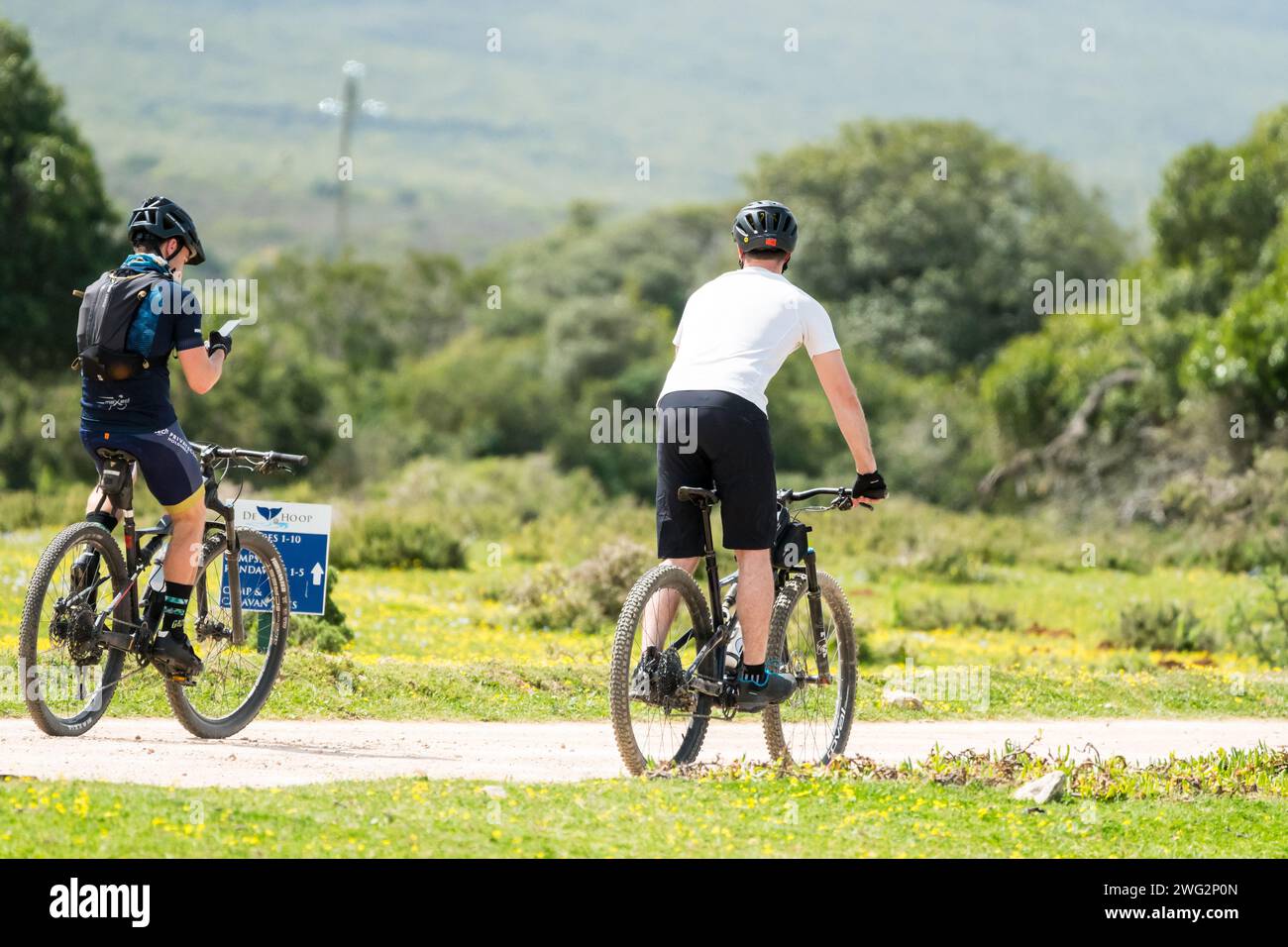 Due ciclisti maschi attraversano in bicicletta la riserva naturale De Hoop, Capo Occidentale, Sud Africa concetto di attività ricreative e di svago nella natura Foto Stock