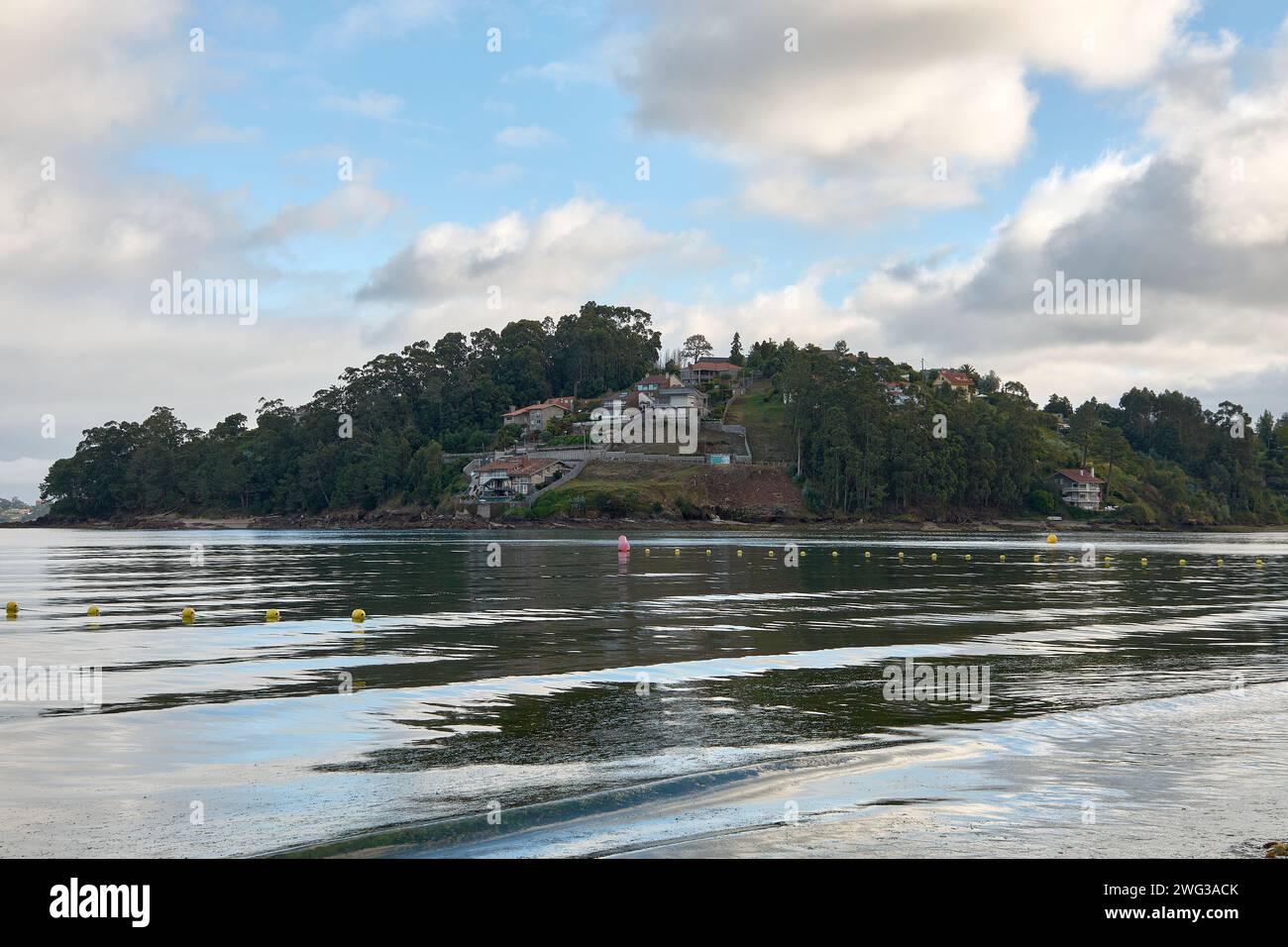 Un cielo con nuvole, dalla spiaggia di Ladeira a Baiona si può vedere Monte Lourido dove ci sono varie case Foto Stock