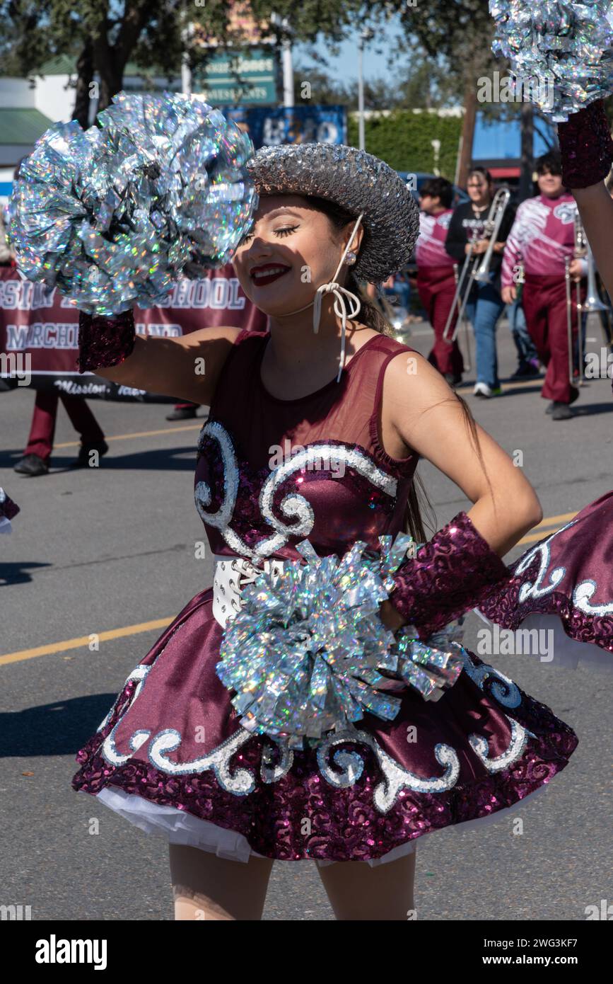 Giovane donna in costume corto con paillettes e glitter, con pompini, marce in Parata degli arance 2024, parte di Citrus Fiesta, Mission, Texas, USA. Foto Stock