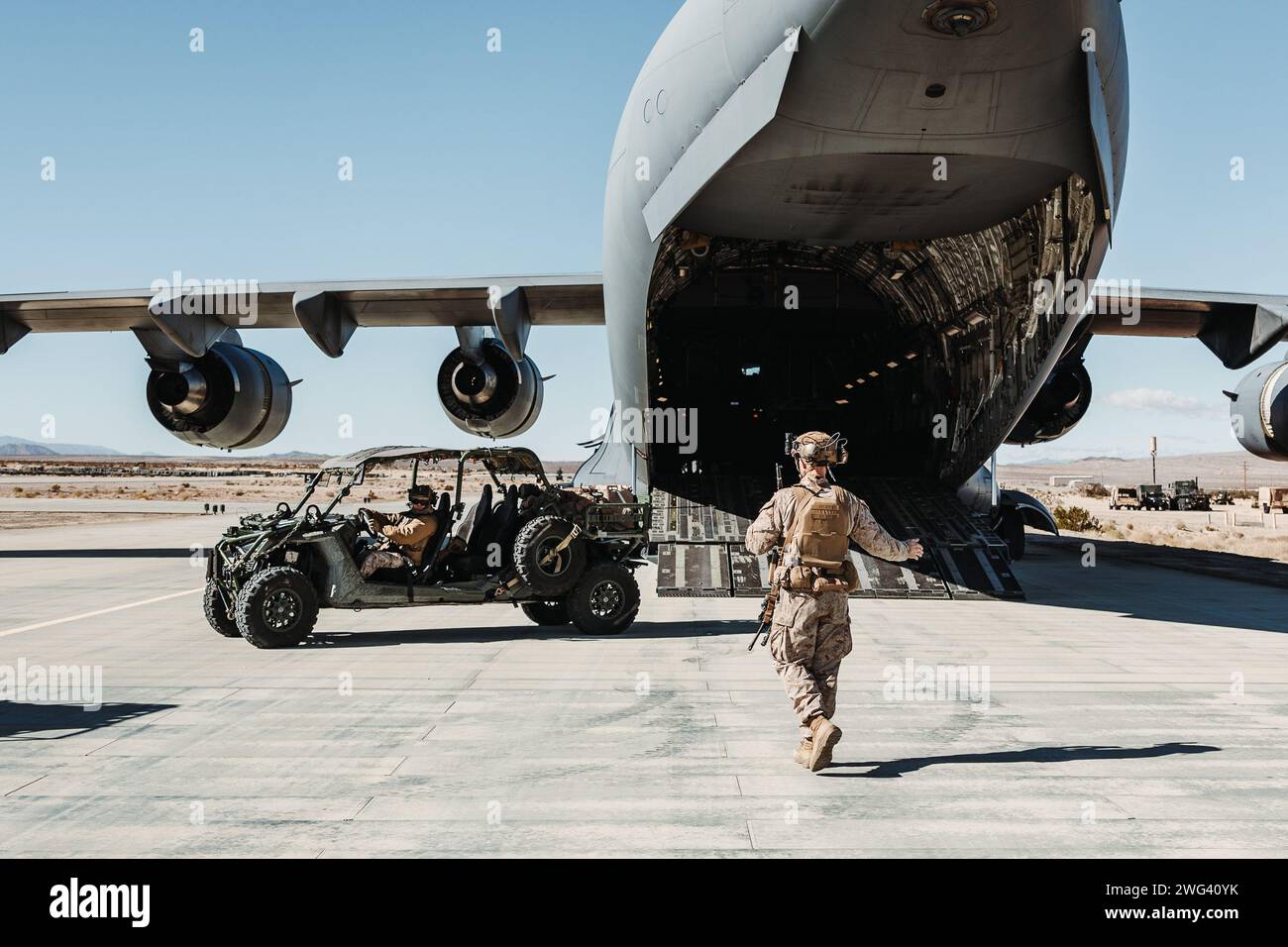 U.S. Marines with 3rd Light Armored Reconnaissance Battalion, 1st Marine Division, 1st Marine Expeditionary Force, caricare un veicolo tattico Ultra-Light su un U.S. Air Force C-17 Globemaster III assegnato al 14th Airlift Squadron, 437th Airlift Wing, durante un esercizio di mobilità strategica, come parte dell'esercitazione Service Level Training 2-24 a Camp Wilson, Marine Corps Air-Ground Combat Center, Twentynine Palms, California, 25 gennaio 2024. L'interoperabilità congiunta tra l'Air Force e il corpo dei Marines degli Stati Uniti consente alle unità dei Marines di imbarcarsi rapidamente sui C-17, consentendo al corpo dei Marines di fornire su Foto Stock